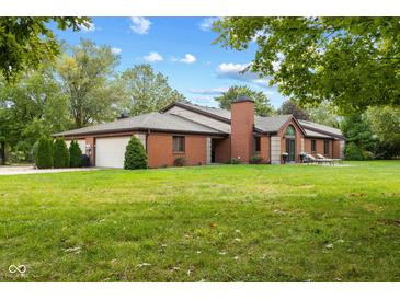 Brick ranch home with attached two-car garage and lush green lawn at 9263 Golden Oaks W, Indianapolis, IN 46260
