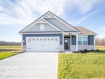 Charming two-story home with a blue and gray exterior, white garage door, and landscaped yard at 5628 Cattail Branch Ln, Clayton, IN 46118