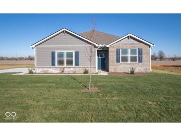 Gray and brick one-story home with a landscaped lawn and blue door at 7920 Magnolia St, New Palestine, IN 46163