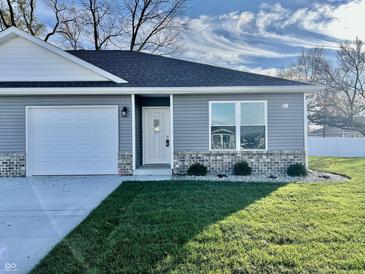 Gray ranch house with white garage door, landscaping, and a brick accent at 1441 Coen Ct, Columbus, IN 47201
