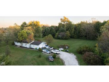 Aerial view of a house with a yard and driveway, surrounded by trees at 3231 W State Road 32, Westfield, IN 46074