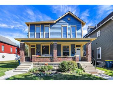 Blue and yellow two-story house with a brick porch at 1007 Broadway St, Indianapolis, IN 46202