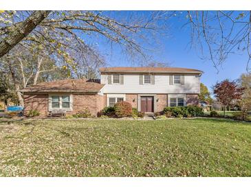 Brick two-story house with a spacious lawn and mature trees at 595 Hawthorne Dr, Carmel, IN 46033