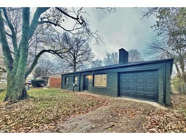 Dark-painted brick ranch house with a dark-painted garage door and a manicured lawn at 2442 N Franklin Rd, Indianapolis, IN 46219