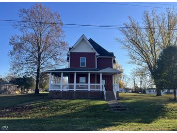 Two-story red house with white trim, a porch, and a well-maintained lawn at 503 E Clyde St, Frankton, IN 46044