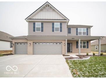 Two-story house with gray siding, brick accents, and a three-car garage at 259 Lar Lan Dr, Danville, IN 46122