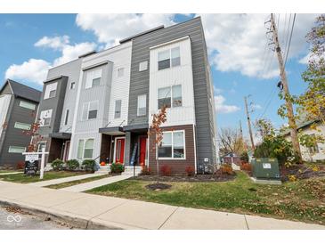 Modern three-story townhome with gray and white siding, red door, and landscaping at 1014 Sterling St, Indianapolis, IN 46201