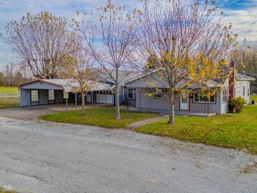 Gray house with carport and mature trees in the front yard at 943 N 12Th St, Elwood, IN 46036