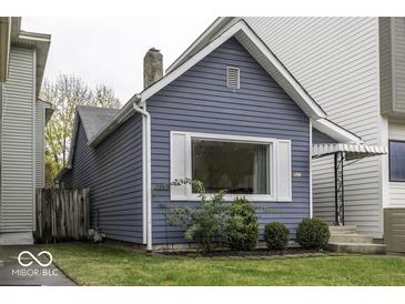 Side view of a charming blue bungalow with landscaping at 907 S East St, Indianapolis, IN 46225