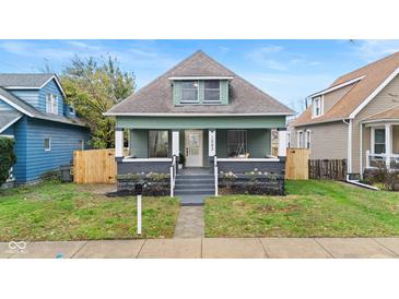 Charming green house with gray accents, a porch, and a well-maintained lawn at 1542 S Alabama St, Indianapolis, IN 46225