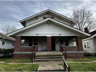 Two-story duplex with brick facade and front porch at 3435 Carrollton Ave, Indianapolis, IN 46205