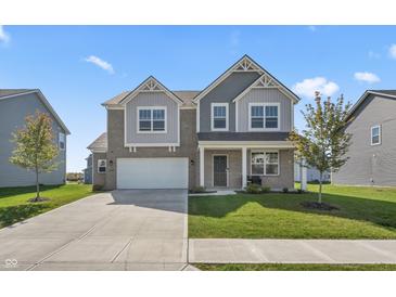 Two-story brick home with gray accents, a white garage door, and a landscaped lawn at 10797 Walden Ln, Brownsburg, IN 46112