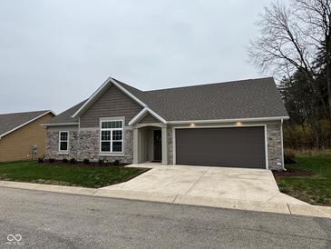 One-story home with stone and brown siding, two-car garage, and landscaped lawn at 4204 W Palomino Ct, Muncie, IN 47304