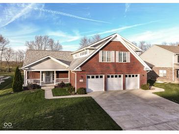Brick home with two-car garage and landscaped lawn at 11736 Grazing Ln, Indianapolis, IN 46239