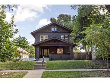 Two-story house with a dark exterior, steps, and a well-maintained lawn at 3907 N Park Ave, Indianapolis, IN 46205