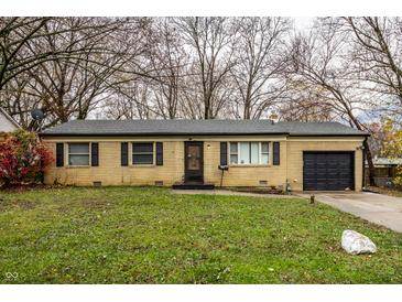 Ranch style home with brick facade, attached garage, and grassy lawn at 3920 N Layman Ave, Indianapolis, IN 46226