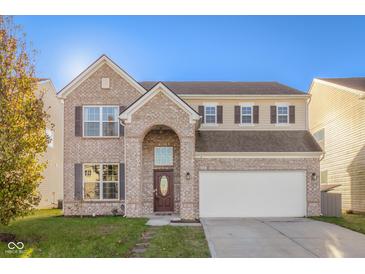 Two story brick home with a large front yard and attached two car garage at 2291 Creek Bank Dr, Columbus, IN 47201