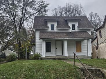 White two-story house with brown roof, steps, and small lawn at 2702 Boulevard Pl, Indianapolis, IN 46208