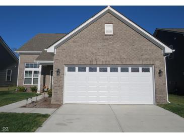 Brick house with a white garage door and landscaped lawn at 10538 Rose Mill Dr, Lawrence, IN 46235