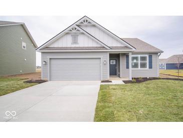 Gray house with white accents, a two-car garage, and a landscaped lawn at 5607 Tart Blvd, Indianapolis, IN 46239