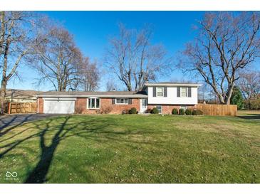 Brick ranch home with attached garage and large yard at 8145 N Richardt Ave, Indianapolis, IN 46256