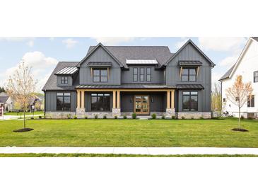 Two-story farmhouse with gray siding, stone accents, and a welcoming front porch at 5187 Abington Way, Zionsville, IN 46077