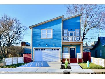 Stunning two-story blue house with a white garage door and landscaped lawn at 2318 E Brookside Ave, Indianapolis, IN 46218