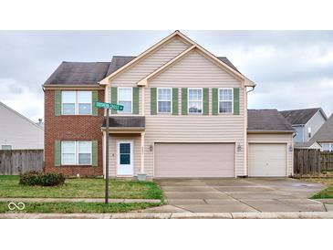 Two-story house with brick and beige siding, two-car garage, and landscaped yard at 8231 Golden Ridge Ln, Indianapolis, IN 46237