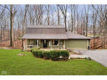 Green house with brown roof, attached garage, and landscaped yard at 1850 White Oak W Ln, Martinsville, IN 46151