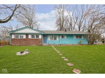 Brick ranch home with teal siding, landscaped lawn, and stone walkway at 1535 N Glen Arm Rd, Indianapolis, IN 46214