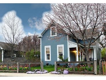 Charming blue house with flower garden and wooden fence at 410 Terrace Ave, Indianapolis, IN 46225