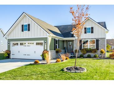 Two-story house with a green and white exterior, landscaping, and a two-car garage at 5037 Gerhing Dr, Indianapolis, IN 46239