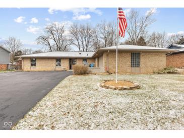 Brick ranch home with landscaped yard and American flag at 8026 Delbrook Dr, Indianapolis, IN 46260