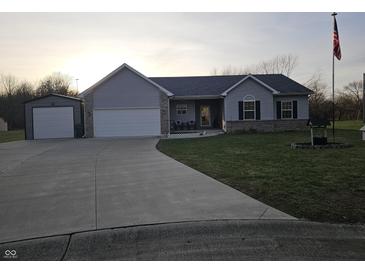 Charming two-story home with a two-car garage, a detached garage, a covered porch, and a large driveway at 2039 Round Barn Ct, Anderson, IN 46017