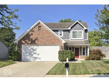 Charming two-story home with a red door, attached garage, and landscaped front yard at 5810 Spring Oaks Way, Indianapolis, IN 46237