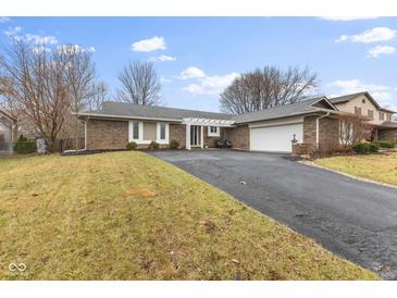 Brick ranch home with attached garage and landscaped lawn at 8008 Delbrook Dr, Indianapolis, IN 46260