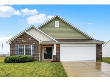 Charming two-story home with a green and beige facade, attached garage, and landscaped front yard at 878 Cherry Tree Ln, Greenwood, IN 46143