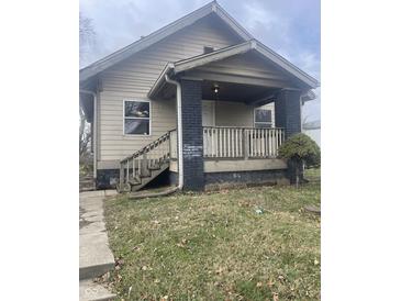 Tan house with front porch and steps, nicely landscaped yard at 218 S Walcott St, Indianapolis, IN 46201