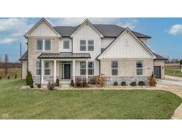 Two-story farmhouse with stone and white siding, landscaping, and a welcoming front porch at 16222 Browning Ct, Fishers, IN 46037