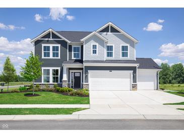 Two-story home with gray and white siding, three-car garage, and landscaped lawn at 595 Bluestem Ln, New Whiteland, IN 46184