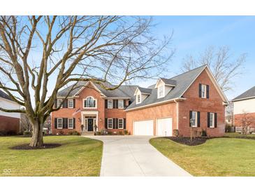 Brick two-story home with three-car garage and landscaped lawn at 12540 Sandstone Run, Carmel, IN 46033