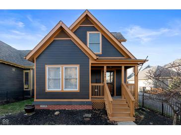 Charming two-story dark gray house with orange accents and a wooden porch at 1550 Bellefontaine St, Indianapolis, IN 46202