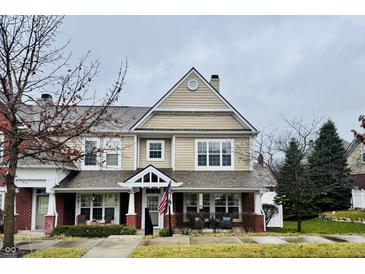 Beige two-story townhome with brick accents and a welcoming front porch at 645 Marana Dr, Carmel, IN 46032