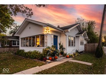 Charming white house with blue door, landscaping, and a welcoming front porch at 5162 Crittenden Ave, Indianapolis, IN 46205