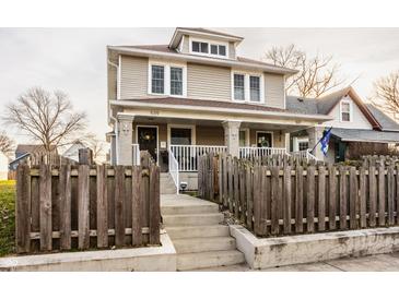 Tan two-story house with a front porch and wooden fence at 539 Jefferson Ave, Indianapolis, IN 46201