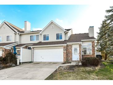 Tan two-story townhome with attached garage and landscaping at 6565 Green Haven Way # D, Indianapolis, IN 46214