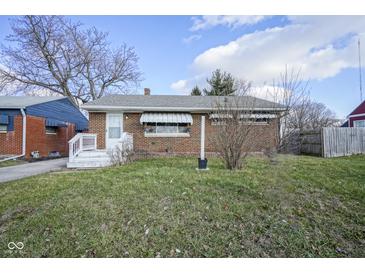 Brick ranch home with a white porch and a well-maintained lawn at 33 S Post Rd, Indianapolis, IN 46219