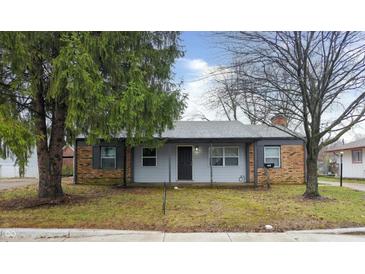 Brick ranch house with gray trim, shutters, and a small front yard at 5701 Regency Dr, Indianapolis, IN 46224