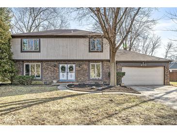 Brick two-story house with attached garage and landscaped lawn at 409 Lansdowne Rd, Indianapolis, IN 46234