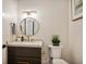 Stylish powder room with a round mirror and dark vanity at 41 N Rangeline Rd # 2, Carmel, IN 46032